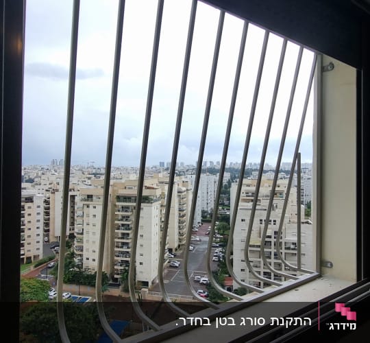 סורגי מתכת על חלון עם נוף עירוני
